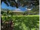 Beautiful lawn area with lush landscaping, trees, and a view of the home's exterior at 13807 Eagles Rock Ct, Hudson, FL 34667