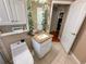 Bright bathroom with a tile floor, single sink, toilet, and an open door to the closet at 13807 Eagles Rock Ct, Hudson, FL 34667