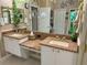 Well-lit bathroom with double sinks, granite countertops, and decorative wall accents at 13807 Eagles Rock Ct, Hudson, FL 34667