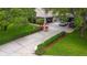 Extended driveway leading to a home with a three-car garage, beautiful shrubs and an American flag at 13807 Eagles Rock Ct, Hudson, FL 34667
