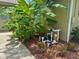 Landscaped yard and side view of property features lush banana trees and pool equipment at 13807 Eagles Rock Ct, Hudson, FL 34667
