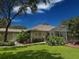 Landscaped yard and neutral home exterior including an enclosed pool area at 13807 Eagles Rock Ct, Hudson, FL 34667