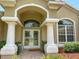 Welcoming front entrance features grand columns, arched entryway, and glass double doors at 13807 Eagles Rock Ct, Hudson, FL 34667