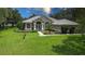 Charming one-story home with well-manicured lawn, mature trees, and elegant architectural details at 13807 Eagles Rock Ct, Hudson, FL 34667