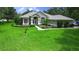 Beautiful one-story home with lush green lawn, landscaped beds, and a welcoming front entrance at 13807 Eagles Rock Ct, Hudson, FL 34667