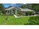 Beautiful single-story home with a well-manicured lawn, mature trees, and attractive landscaping at 13807 Eagles Rock Ct, Hudson, FL 34667