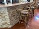 Kitchen bar showcases stone accents and an elegant granite countertop with seating, and hardwood flooring at 13807 Eagles Rock Ct, Hudson, FL 34667