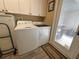 Bright laundry room with white cabinets, washer, dryer, and convenient outdoor access at 13807 Eagles Rock Ct, Hudson, FL 34667
