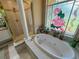 Bathroom offers a large soaking tub next to a beautiful stained glass window at 13807 Eagles Rock Ct, Hudson, FL 34667