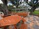 Outdoor picnic area features multiple tables and benches on a multicolored brick patio at 13807 Eagles Rock Ct, Hudson, FL 34667
