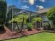 A screened enclosure surrounds the pool area, complemented by palm trees and greenery at 13807 Eagles Rock Ct, Hudson, FL 34667