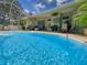 Sparkling screened-in pool with plenty of seating, a ceiling fan, and lovely outdoor views at 13807 Eagles Rock Ct, Hudson, FL 34667