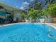 Screened in pool area with outdoor furniture and tropical foliage at 13807 Eagles Rock Ct, Hudson, FL 34667