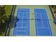 Overhead shot of blue and green tennis courts showing nets and court lines at 13807 Eagles Rock Ct, Hudson, FL 34667