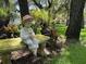 Charming yard featuring a statue sitting on a decorative stone bench at 13807 Eagles Rock Ct, Hudson, FL 34667