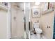 Bathroom with glass-enclosed shower, toilet, and wall shelves at 147 Bluff View Dr # 105, Belleair Bluffs, FL 33770