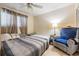 Cozy bedroom features two twin beds, tile floors, ceiling fan, and an armchair under soft lamp light at 147 Bluff View Dr # 105, Belleair Bluffs, FL 33770