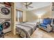 Cozy bedroom features two twin beds, tile floors, ceiling fan, armchair, and stacked washer/dryer unit at 147 Bluff View Dr # 105, Belleair Bluffs, FL 33770