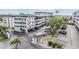 An exterior view of the condo complex showing multi-level buildings, parking, a guard house, and landscaping at 147 Bluff View Dr # 105, Belleair Bluffs, FL 33770
