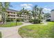 A serene outdoor space features lush greenery, winding sidewalks, and tables with chairs for residents at 147 Bluff View Dr # 105, Belleair Bluffs, FL 33770