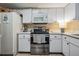 An efficient kitchen with white cabinetry, a microwave, and a stainless-steel range at 147 Bluff View Dr # 105, Belleair Bluffs, FL 33770
