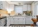White kitchen showcasing a stainless steel oven, ample counter space, and tiled backsplash at 147 Bluff View Dr # 105, Belleair Bluffs, FL 33770