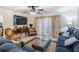 Comfortable living room featuring tile floors, plush blue sofas, and a ceiling fan at 147 Bluff View Dr # 105, Belleair Bluffs, FL 33770