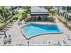 Community pool surrounded by lounge chairs and tables with umbrellas, with shade structures at 147 Bluff View Dr # 105, Belleair Bluffs, FL 33770