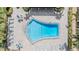 Aerial view of community pool surrounded by lounge chairs and tables with umbrellas at 147 Bluff View Dr # 105, Belleair Bluffs, FL 33770