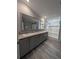 Bathroom with double vanity, shower, and wood-look flooring at 15591 Charmwood Dr, Hudson, FL 34667