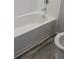 Clean bathroom with a white bathtub and gray wood-look flooring at 15591 Charmwood Dr, Hudson, FL 34667