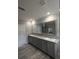 Bathroom featuring a long vanity with double sinks and three-panel mirror at 15591 Charmwood Dr, Hudson, FL 34667