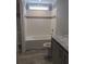 White tiled shower and tub combo in a neutral bathroom with granite counters at 15591 Charmwood Dr, Hudson, FL 34667