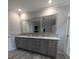 Bathroom vanity with double sinks and mirrors and wood-look floors at 15591 Charmwood Dr, Hudson, FL 34667