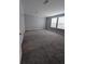 Spacious carpeted bedroom with trim, two windows that offer natural light, and neutral wall paint at 15591 Charmwood Dr, Hudson, FL 34667
