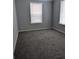Cozy bedroom with neutral walls, plush carpeting, and natural light from two windows at 15591 Charmwood Dr, Hudson, FL 34667