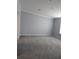 Grey carpeted bedroom features a neutral grey paint, white trim and an off-white ceiling at 15591 Charmwood Dr, Hudson, FL 34667