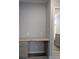 Hallway desk area with gray cabinets and granite top near a bathroom at 15591 Charmwood Dr, Hudson, FL 34667