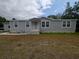 Front view of a charming one-story home featuring light gray siding and a welcoming entrance at 15591 Charmwood Dr, Hudson, FL 34667