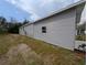 View of the home's light gray vinyl siding, attached garage, and tidy landscaping at 15591 Charmwood Dr, Hudson, FL 34667