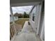 Inviting front porch with white railings leading to a grey single-Gathering home at 15591 Charmwood Dr, Hudson, FL 34667