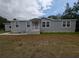 Charming single-story home with gray siding, white trim, and a well-manicured lawn at 15591 Charmwood Dr, Hudson, FL 34667
