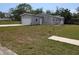 Well-maintained single-Gathering home featuring a grey facade, attached garage, and front lawn at 15591 Charmwood Dr, Hudson, FL 34667