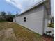 View of the home's light gray vinyl siding, attached garage, and tidy landscaping at 15591 Charmwood Dr, Hudson, FL 34667