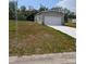 Well-maintained single-Gathering home with a grey facade, attached garage, and side yard at 15591 Charmwood Dr, Hudson, FL 34667