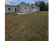 Exterior elevation of a home with gray siding, a manicured lawn, and a charming front porch at 15591 Charmwood Dr, Hudson, FL 34667