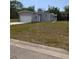 Well-maintained single-Gathering home featuring a grey facade, attached garage, and front lawn at 15591 Charmwood Dr, Hudson, FL 34667