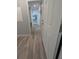 Hallway features wood-look floors that lead to additional rooms with neutral paint at 15591 Charmwood Dr, Hudson, FL 34667