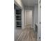 Open hallway with built-in shelves and desk area with wood-look flooring at 15591 Charmwood Dr, Hudson, FL 34667