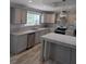 Modern kitchen with gray cabinets, stainless steel appliances, granite counters, and stainless steel sink at 15591 Charmwood Dr, Hudson, FL 34667